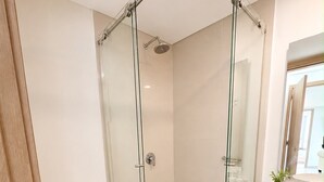 A modern bathroom with a glass-enclosed shower, a toilet, and a vanity with a sink. - Luxurious 2BR Ocean View Condo Rooftop Pool and Jacuzzi (Cartagena de Indias)