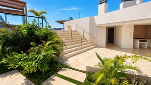 A modern building with a staircase leading to a rooftop terrace, surrounded by lush greenery. - Luxurious 2BR Ocean View Condo Rooftop Pool and Jacuzzi (Cartagena de Indias)