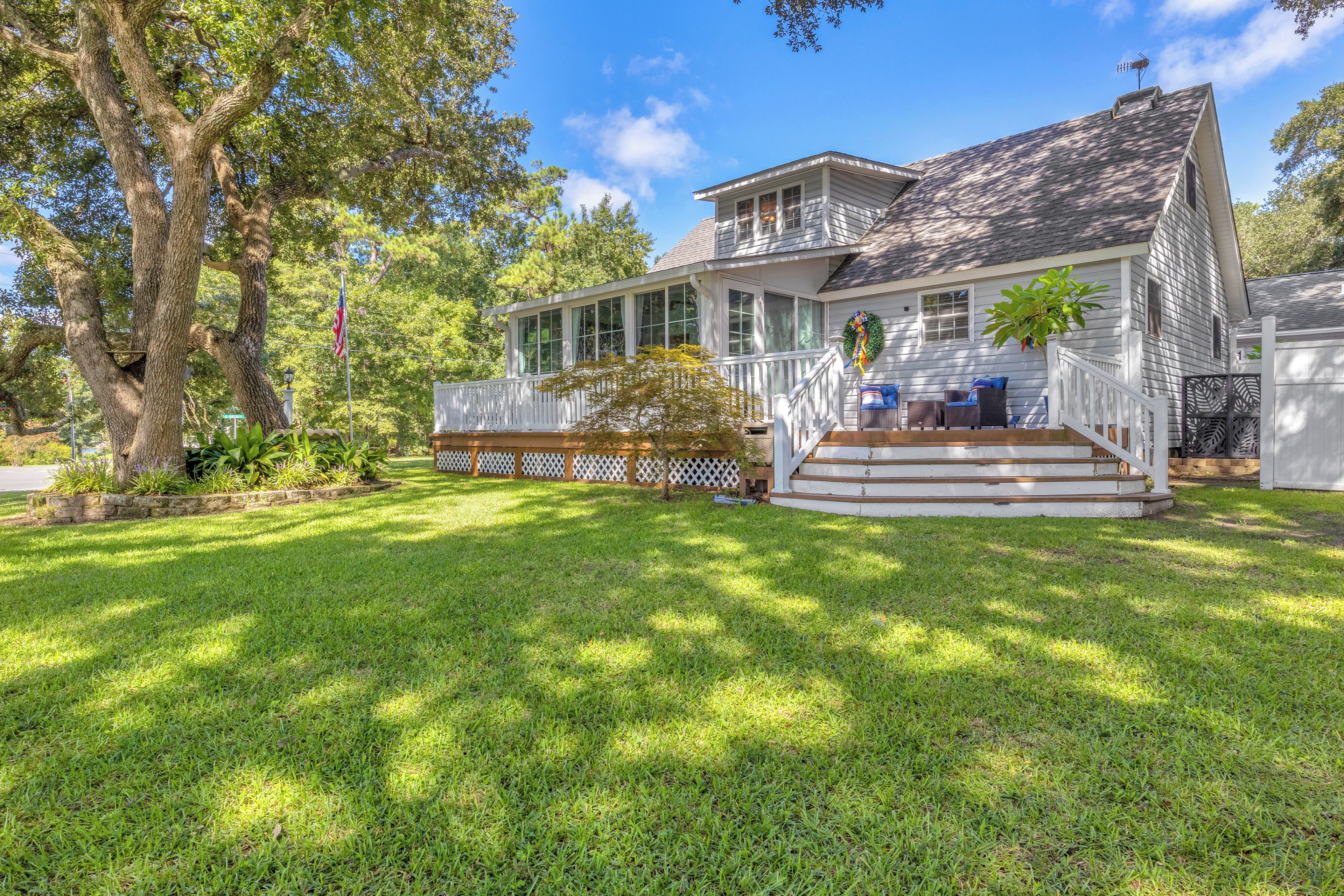 A two-story house with a front porch, a covered patio, and a well-maintained lawn.