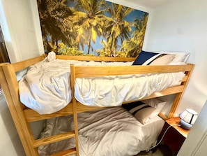 Un lit superposé avec une fresque tropicale en arrière-plan.