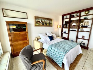 A bedroom with a bed, a desk, a chair, a bookshelf, and a painting on the wall. - Perfect 2-bedroom apartment in Arcachon with direct view and access to the beach (Arcachon)