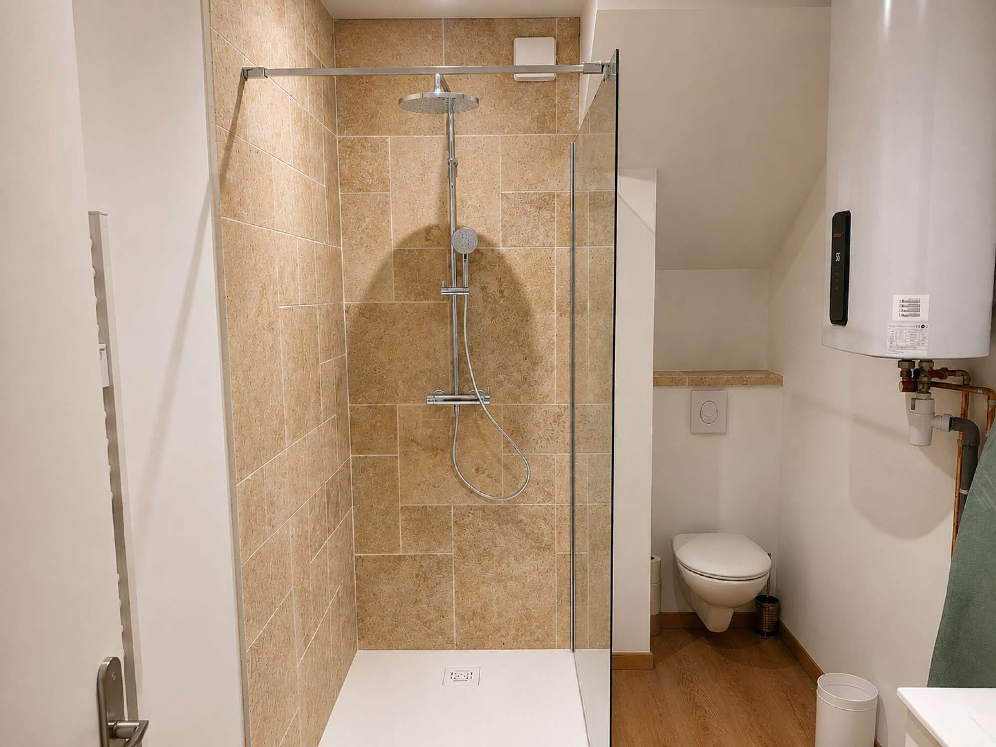 Une salle de bain moderne avec une douche à parois de verre, des toilettes et un lavabo blanc.