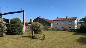 Un barrio residencial con césped, un edificio de piedra y una casa con techo de tejas.