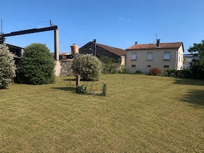 A residential area with a grassy yard, a stone building, and a house with a tiled roof. - L'Échappée d'Ilhonn – Cozy, self-contained studio in Mazamet (Mazamet)
