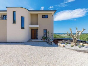 A modern building with a curved facade, a balcony, and a gravel driveway. - Villa Bella 1 (up to 6 people) (Brtonigla)