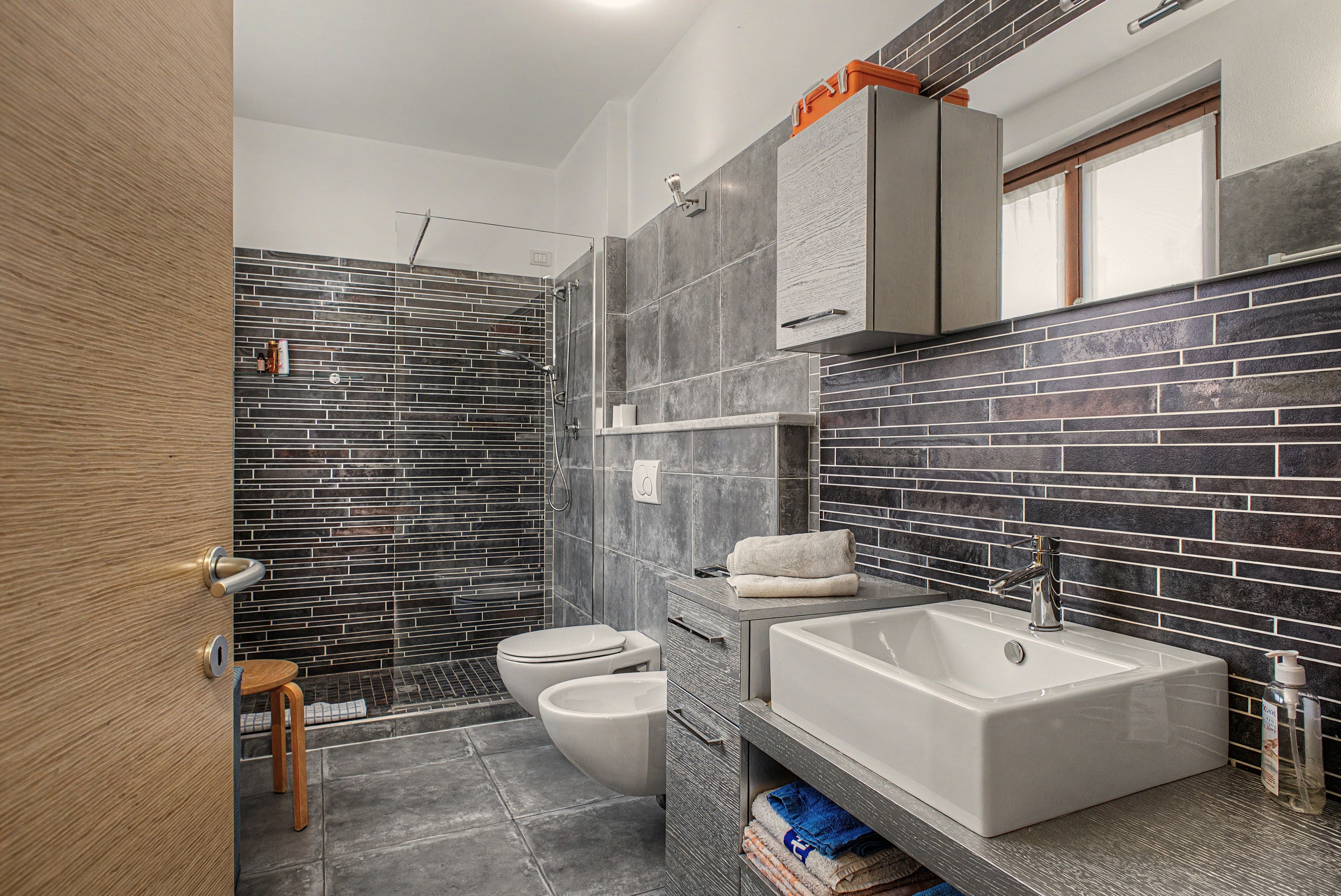 Une salle de bain moderne équipée d’une douche, de toilettes et d’un lavabo.
