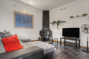 Ein Wohnzimmer mit einer Couch, einem Flachbildfernseher, einem Kamin und modernem Design.