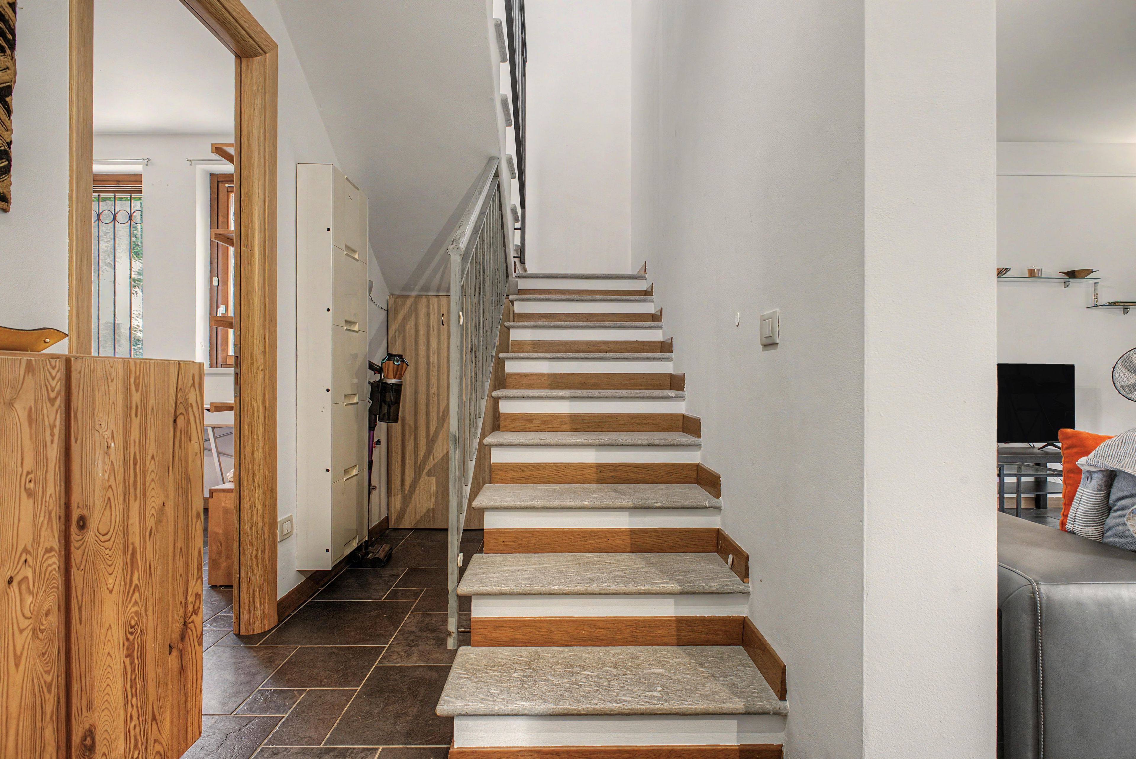 A staircase with alternating white and wooden steps leading to a landing.