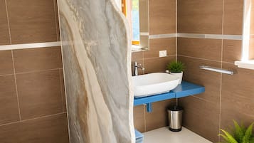 Un bagno con doccia, lavandino e specchio.