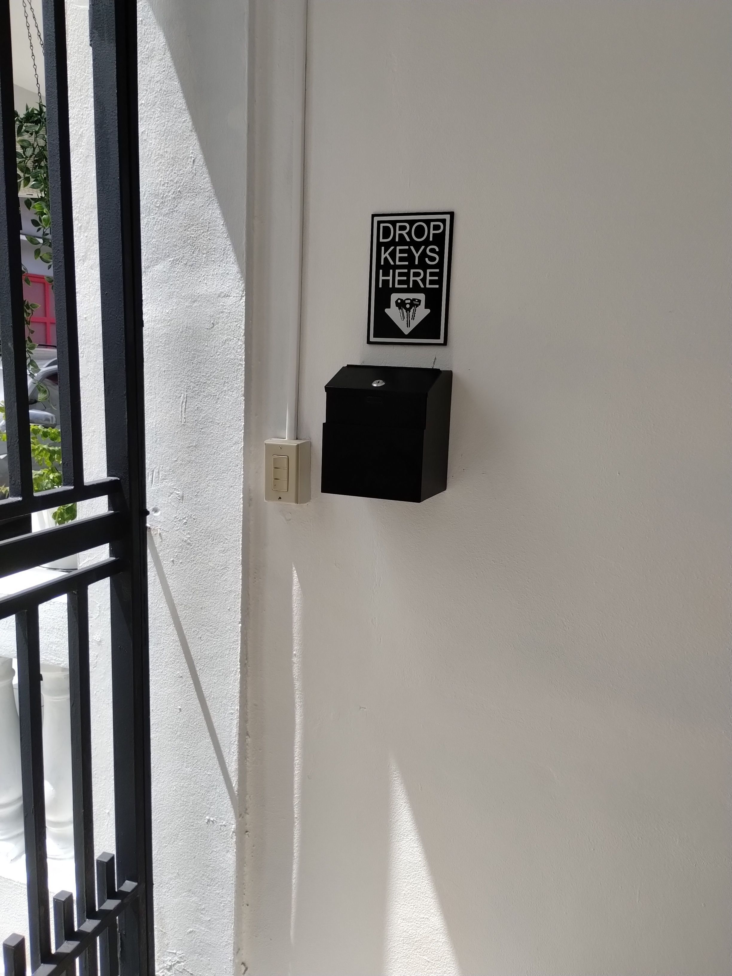 A door with a drop key station and a sign indicating where keys should be dropped.