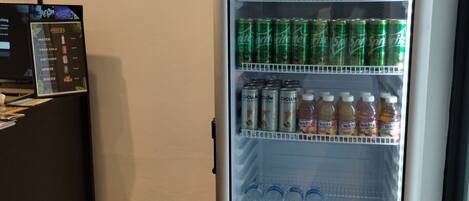 Una máquina expendedora con diversas bebidas, incluyendo Coca-Cola, Sprite y Welch's.