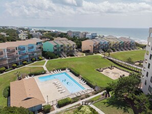 A residential complex with a swimming pool, multiple balconies, and a view of the ocean. - 6th-Floor Oceanview Condo w/ Beautiful Ocean & Sunrise Views (Emerald Isle)
