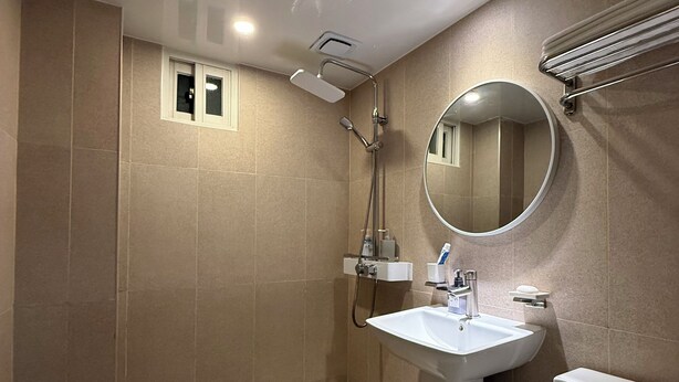 Ein modernes Badezimmer mit Dusche, Waschbecken, Toilette und Spiegel.