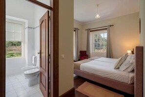 Een slaapkamer met een bed, een raam en uitzicht op het omliggende landschap.