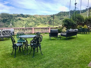 A patio with outdoor furniture, a round table, and chairs. - Villa da Fajã Alta - Room No. 4 (Santana)