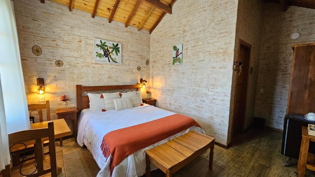 Un dormitorio con cama de madera, un banco, un escritorio y una silla.