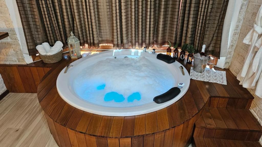 A round bathtub with a wooden surround, a white towel, and a decorative lantern.