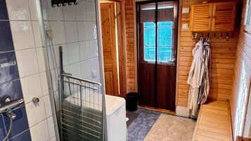 A bathroom with a shower, a toilet, and a sink.