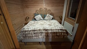 A bed with a fluffy white blanket, a wooden headboard, and two pillows. - Vrbo Property (pello)