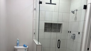 A modern bathroom with a glass-enclosed shower, a toilet, and a granite countertop. - New 3-bedroom house with AC in charming Mapleton with covered walk-out patio. (Mapleton)