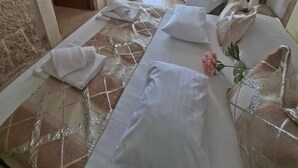 Quarto de hotel com cama, cadeira, escrivaninha e vista para o mar.