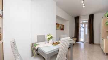 A dining area with a table, chairs, and a vase of flowers.