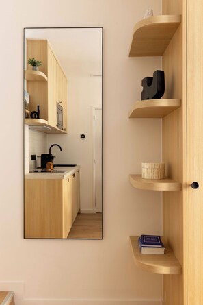 A modern kitchen with wooden cabinetry, a built-in oven, and a coffee machine. - Elegant A/C Apartment 1BR - 4P - Nation (Paris)