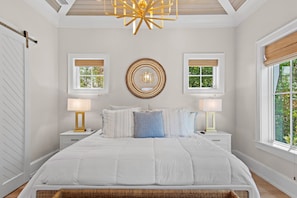 A bedroom with a large bed, two bedside tables, a ceiling light fixture, and two windows with blinds. - Private Pool, 4 King En-suites + Bunk Room, Outdoor Fireplace & Kitchen (Santa Rosa Beach)