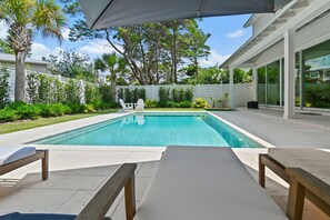 A rectangular swimming pool with clear blue water, surrounded by a white fence, and two lounge chairs facing the pool. - Private Pool, 4 King En-suites + Bunk Room, Outdoor Fireplace & Kitchen (Santa Rosa Beach)