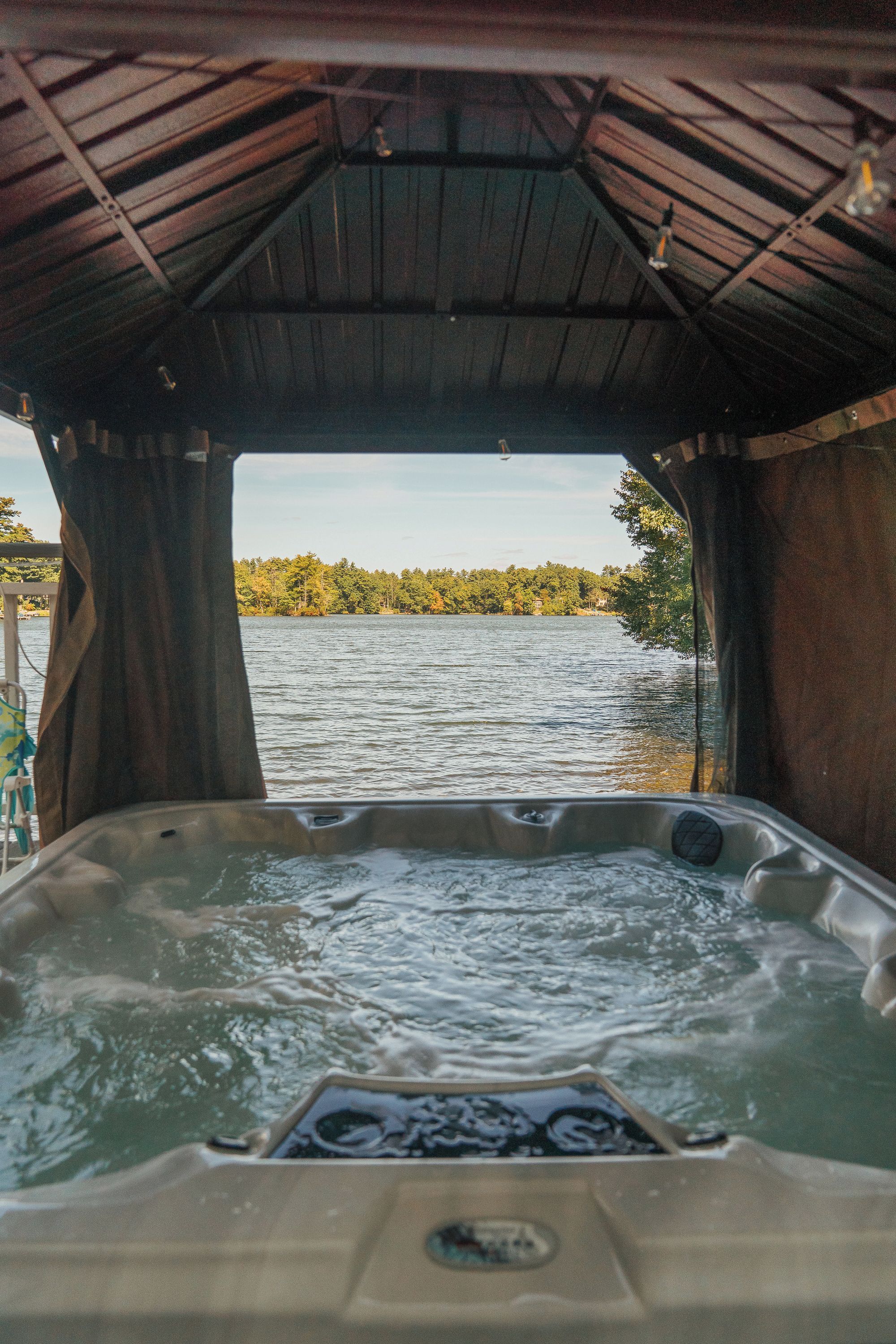 A hot tub with a view of a lake and trees.