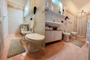 Ein Badezimmer mit zwei Toiletten, einem Bidet, einem Waschbecken und einer Duschkabine.