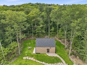 A small house with a dark roof, surrounded by a well-maintained lawn and a stone border. - Spa & Nature in Saint-Come - Oslo-40 (Saint-Côme)