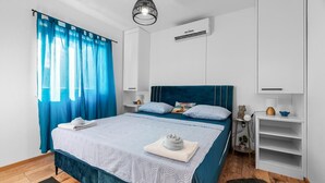 A modern bedroom with a bed, a nightstand, a dresser, and an air conditioning unit. - Villa Niko Dalmatia - Two Bedroom Villa, Sleeps 4 (Raštević)