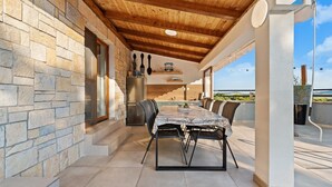 An outdoor dining area with a stone wall, wooden ceiling, and a view of the sea. - Villa Niko Dalmatia - Two Bedroom Villa, Sleeps 4 (Raštević)