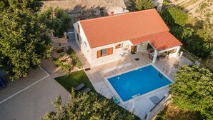 An aerial view of a house with a swimming pool, surrounded by greenery and stone walls. - Villa Niko Dalmatia - Two Bedroom Villa, Sleeps 4 (Raštević)