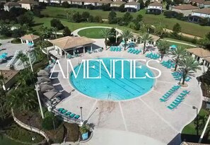 An aerial view of a residential area with a swimming pool surrounded by lounge chairs and palm trees. - 9BR Disney Getaway with Themed Rooms and Theater (Four Corners)