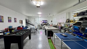 Ein Raum mit Tischfußball, Pong-Tisch und Fernseher.
