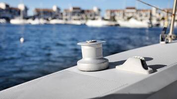 Um close-up do corrimão de um barco, com um carretel de corda branco e um crachá de metal.