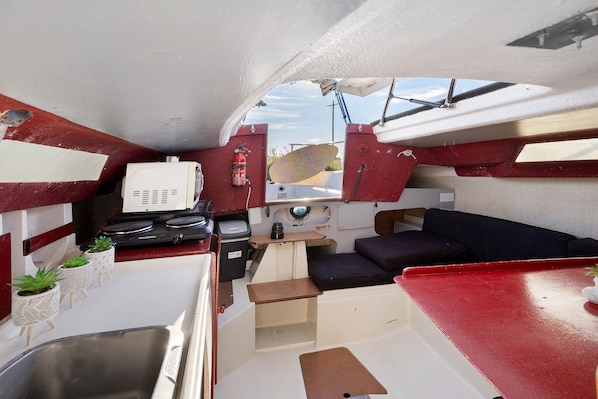 A compact galley with a stove, sink, and seating area.