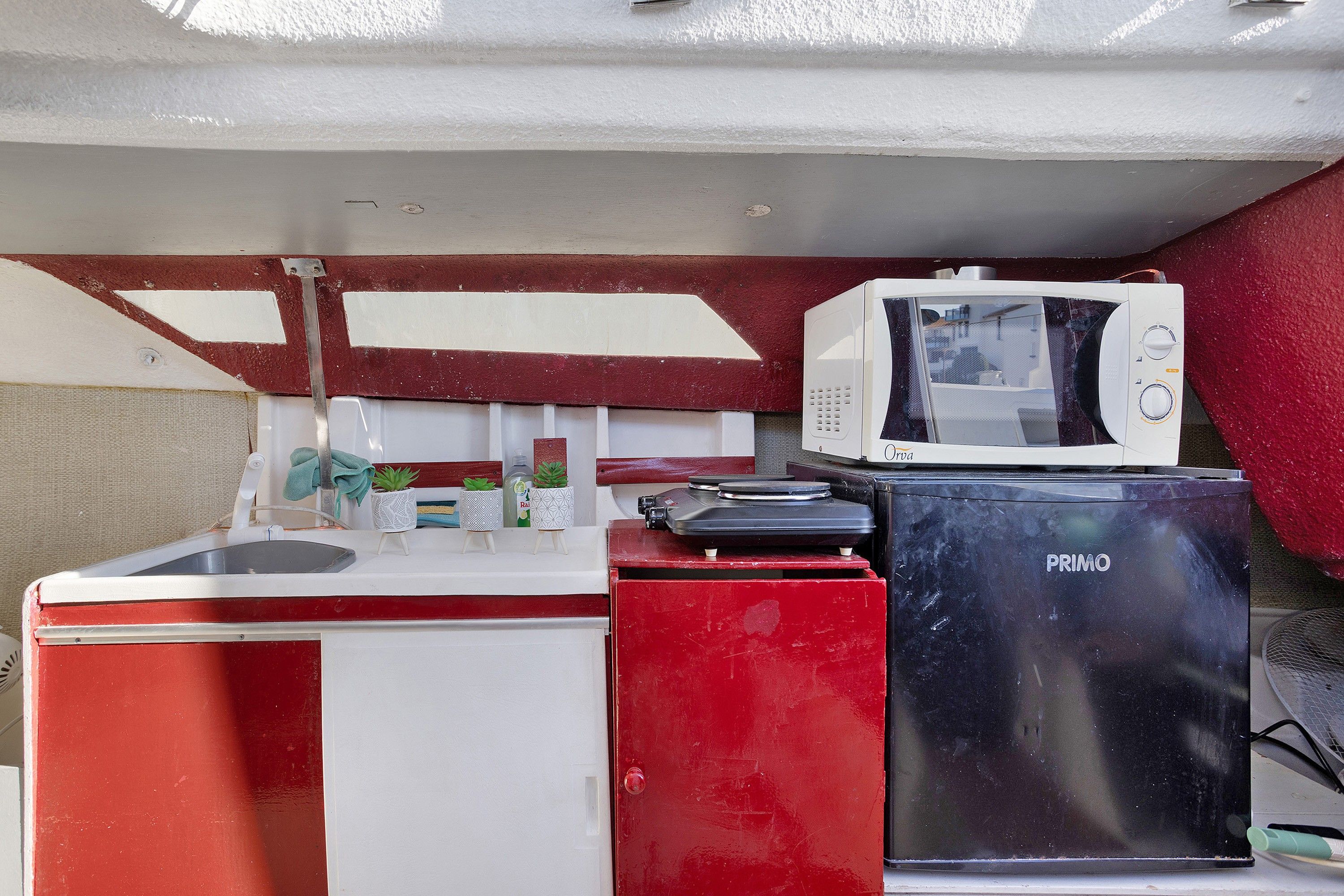 A compact kitchenette with a sink, a microwave, and a small refrigerator.