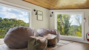 A room with a large window, a wooden ceiling, and a fire extinguisher on the wall. - Indoor Pool, Hot Tub & Mountain Views Near Pigeon Forge (Sevierville)