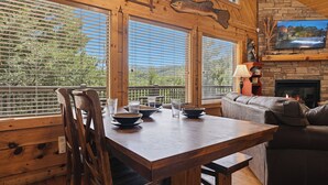 Un intérieur en bois comprenant une table à manger, des chaises, un canapé et une cheminée.