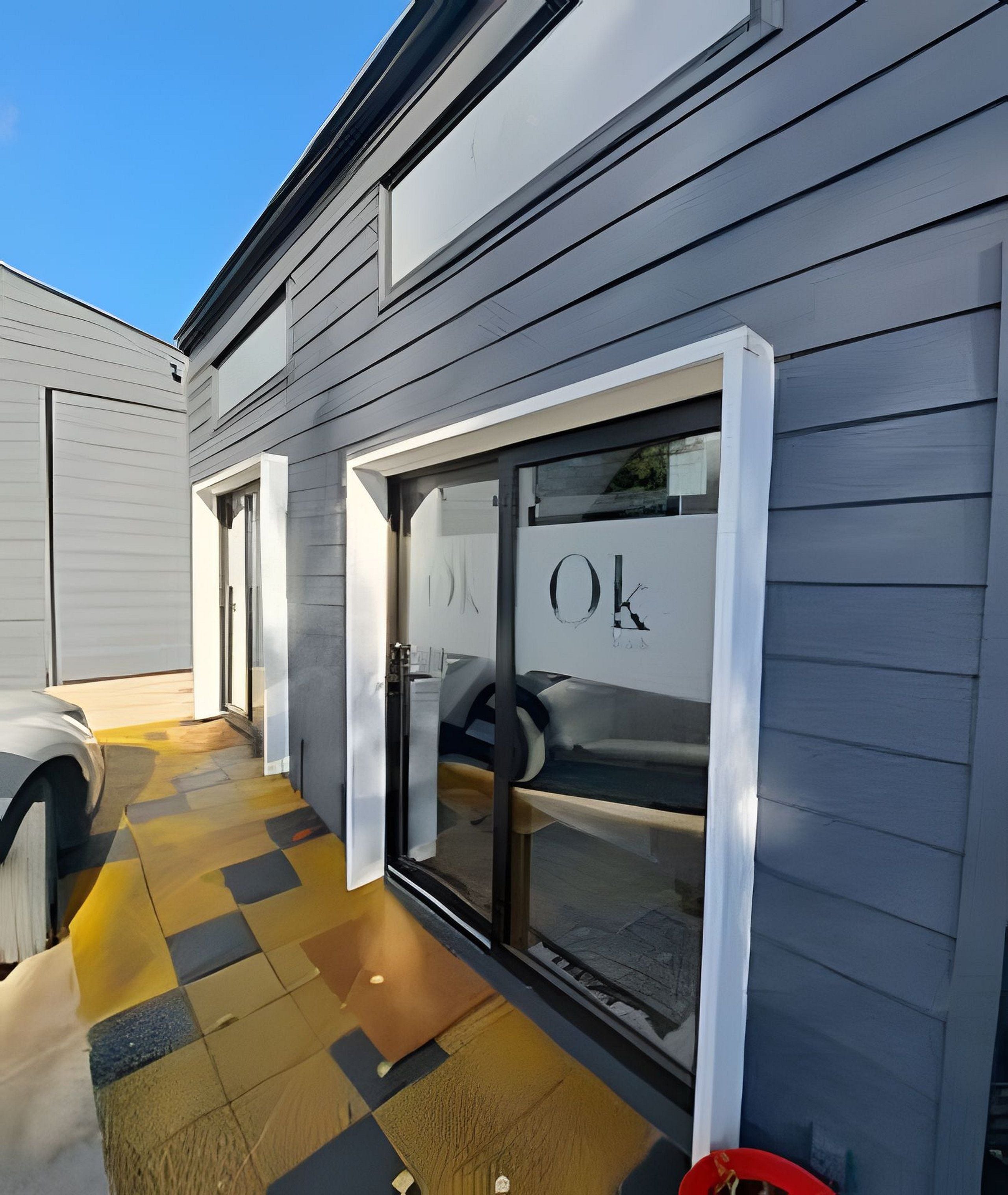 A building with a garage door, a checkered floor, and a clear sky.
