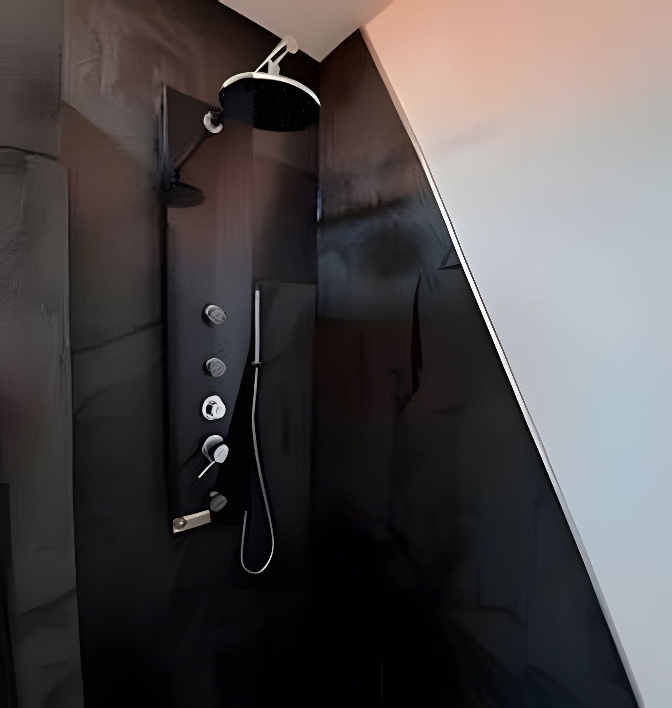A modern shower with a handheld showerhead and a wall-mounted control panel.