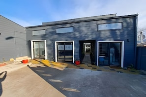 A modern building with a garage entrance, large windows, and a flat roof. - Okeyloft 2 Coyhaique (Coyhaique)