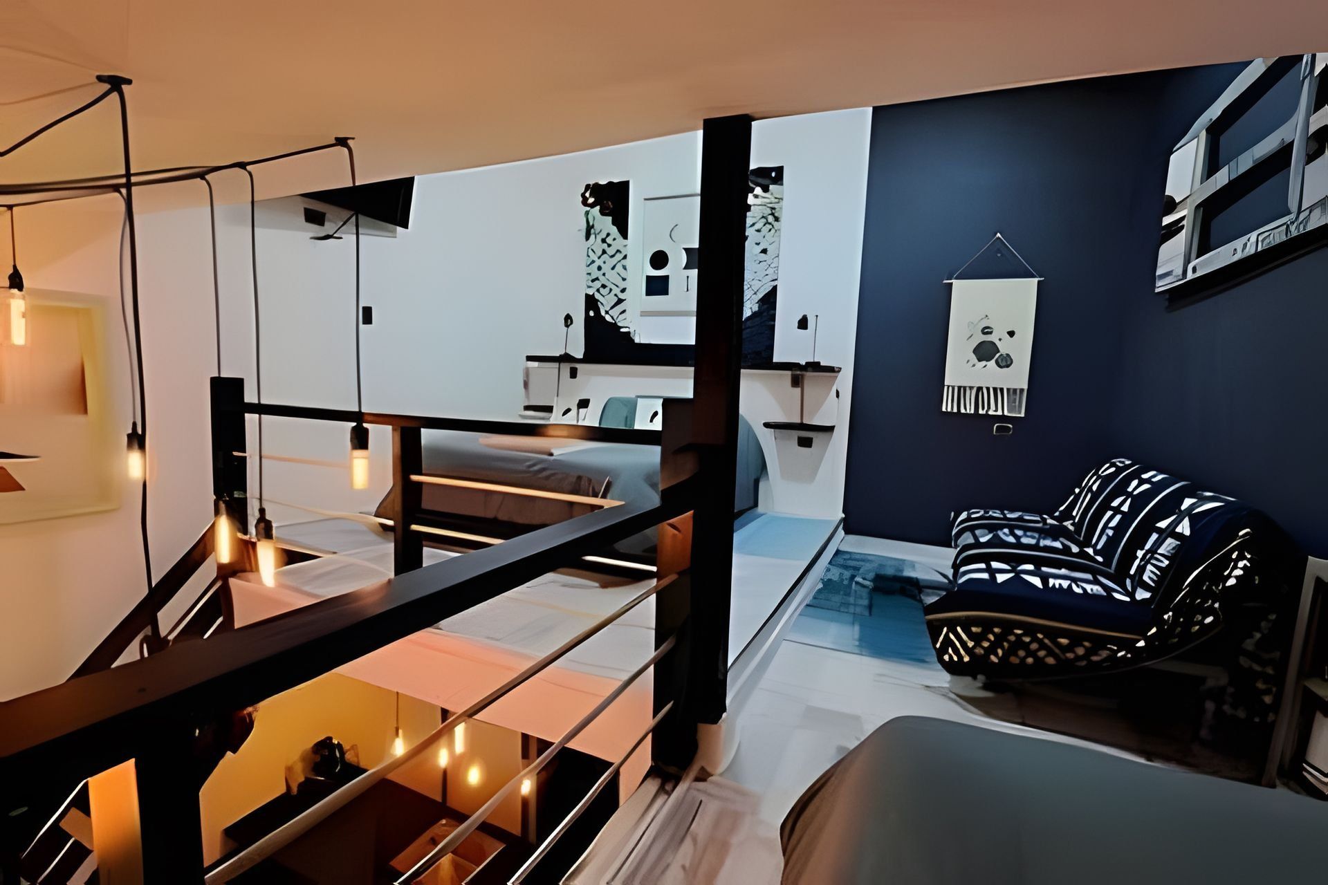 A modern interior with a staircase, a sofa, and a hanging light fixture.