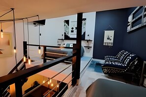 A modern interior with a staircase, a sofa, and a hanging light fixture. - Okeyloft 2 Coyhaique (Coyhaique)