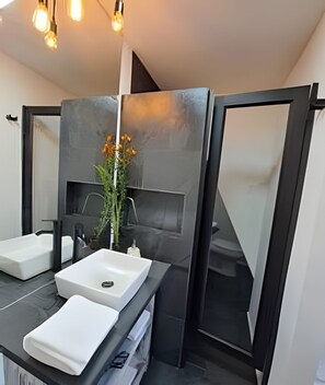 A modern bathroom with a large mirror, two sinks, and a decorative plant. - Okeyloft 2 Coyhaique (Coyhaique)