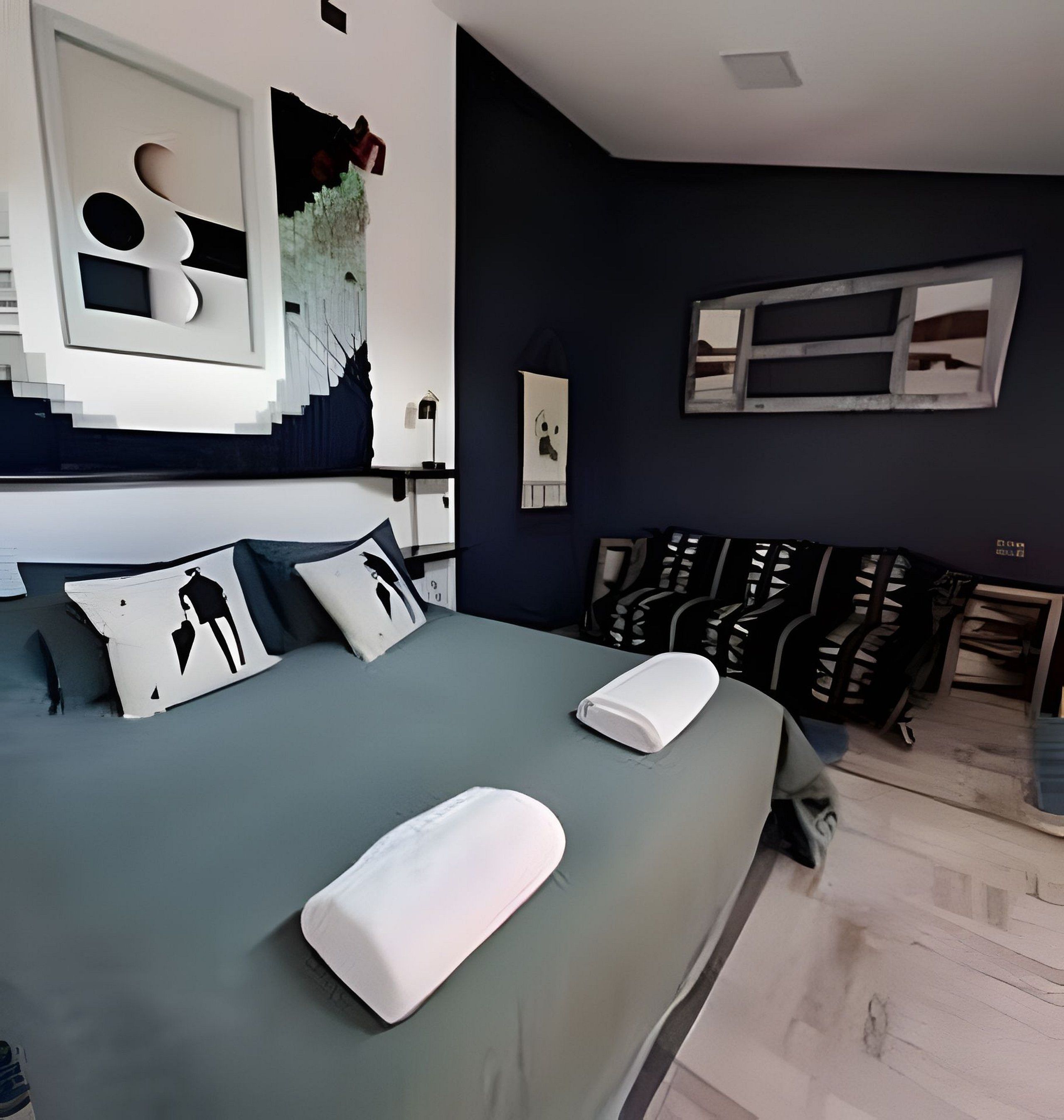 A modern bedroom with a large bed, a desk, and a chair.
