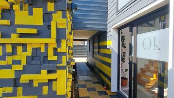 A building with a yellow and black patterned wall, a checkered floor, and a sign with 'Ok' on it.